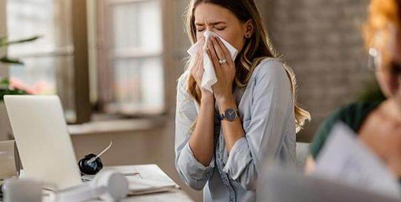rapariga com gripe a trabalhar