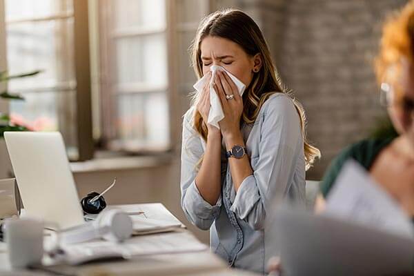 rapariga com gripe a trabalhar