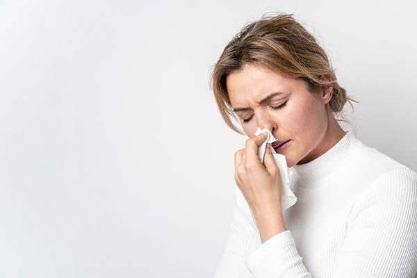 mulher com gripe e nariz entupido